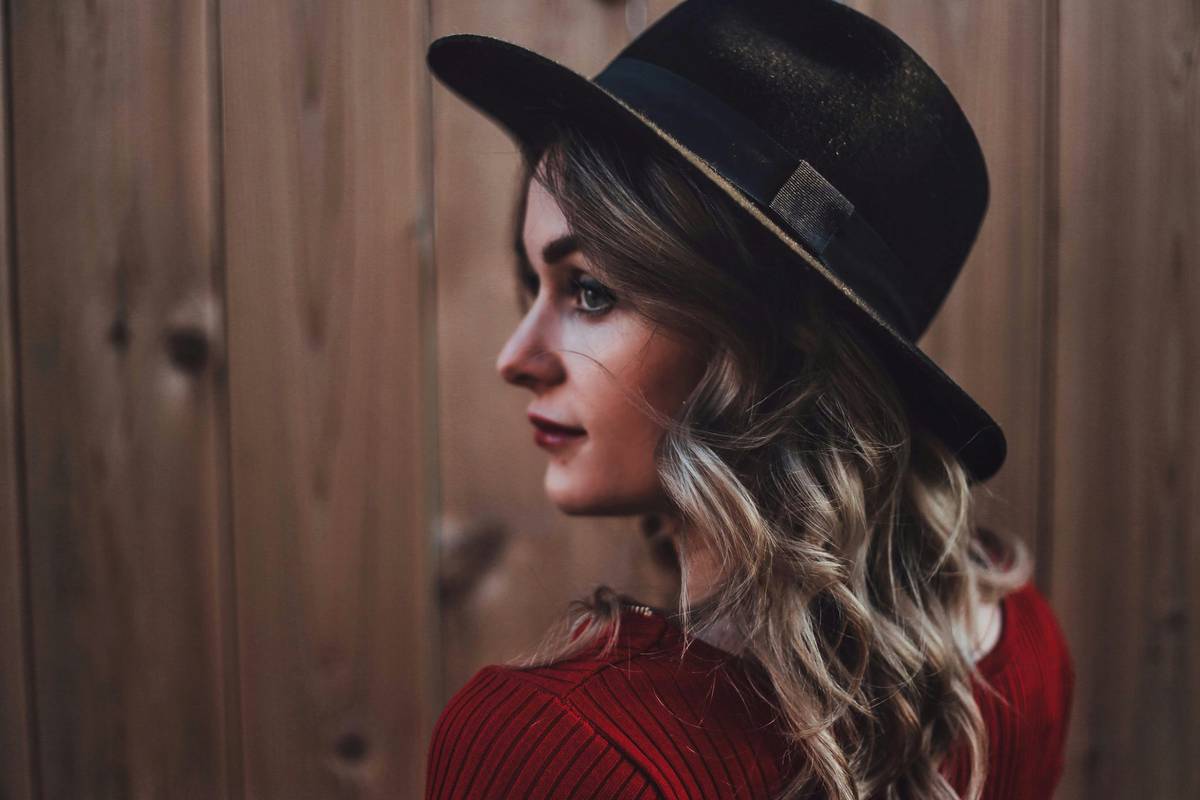 Statement Pieces: A woman wearing a structured beret over soft waves, showcasing balanced styling without hair compression